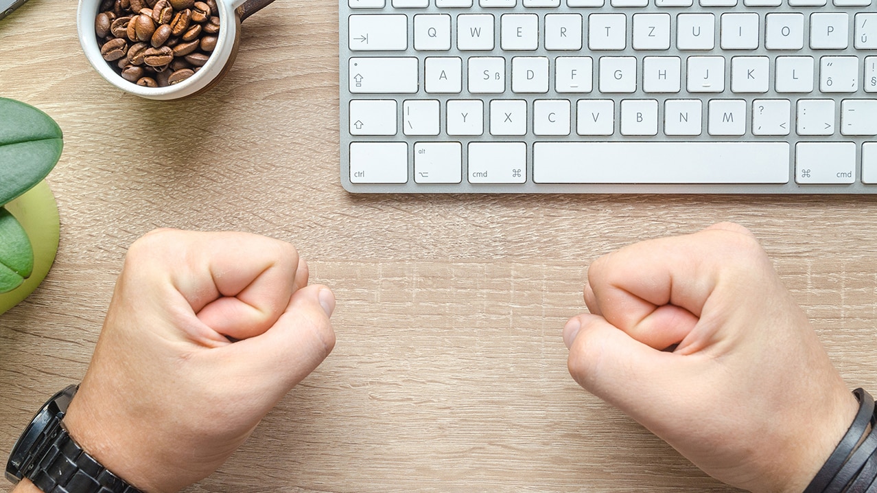 Pair of fists next to computer keyboard